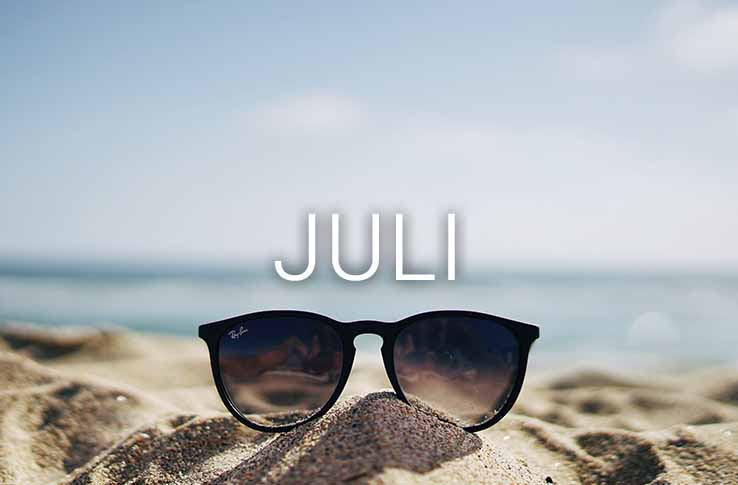 Sonnenbrille am Strand mit dem Text Juli